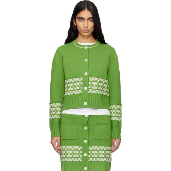 A woman wearing a green checkerboard-trimmed B.B. Wallace knit cardigan and matching skirt