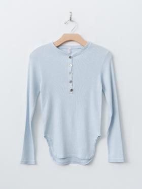 A pale blue babaco long-sleeve henley top on a wooden hanger against a white wall