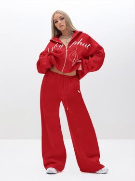 A woman wearing a red Baby Phat zip-up tracksuit with wide-leg sweatpants