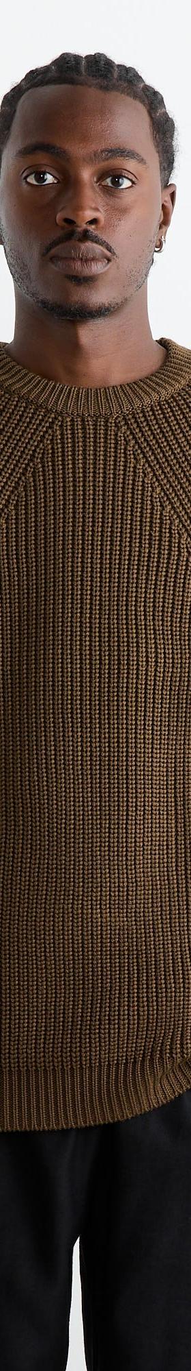 A man wearing a brown ribbed BATONER knit sweater with black trousers