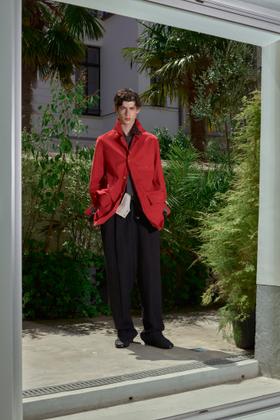 A man wearing a red draped BED j.w. FORD jacket with black wide-leg trousers