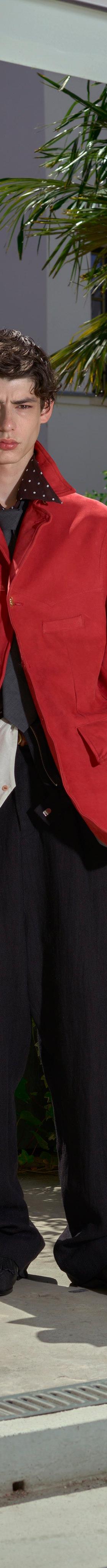A man wearing a red draped BED j.w. FORD jacket with black wide-leg trousers