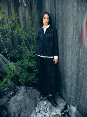 A woman wearing a checked Bergfabel wool jacket and long skirt