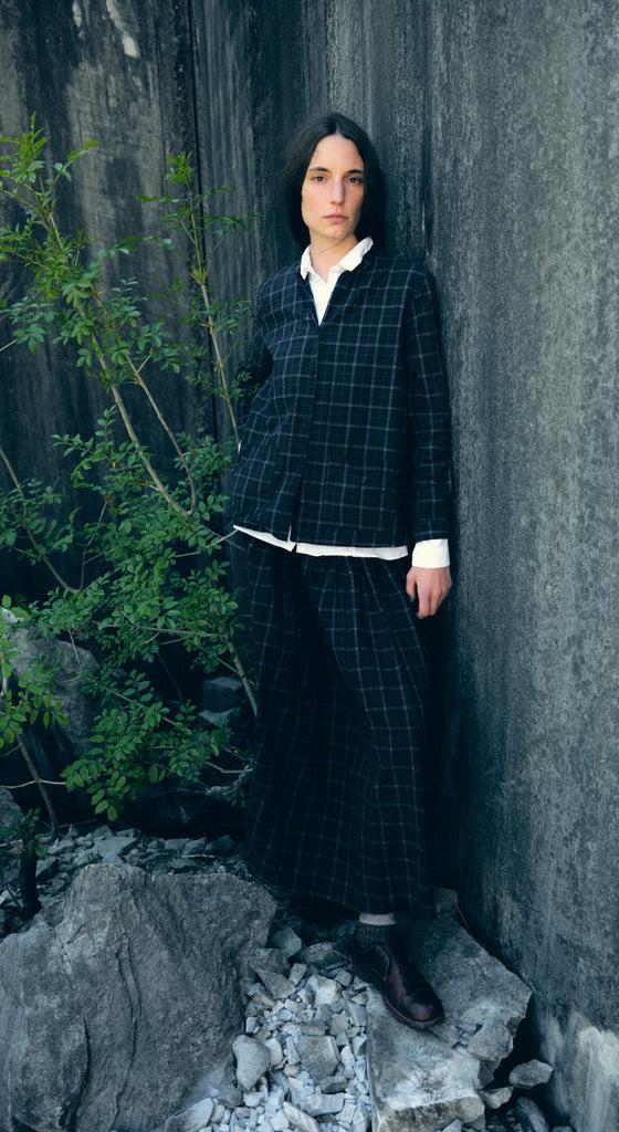 A woman wearing a checked Bergfabel wool jacket and long skirt