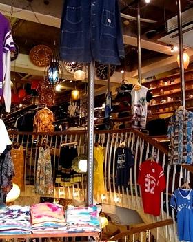BIG TIME men's floor: hanging vintage football jersey and tees, stacked tees, staircase and racks, no people