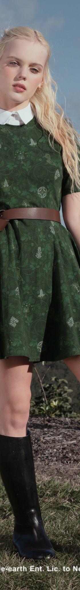 A woman wearing a green printed Black Milk dress with a brown belt and knee-high boots