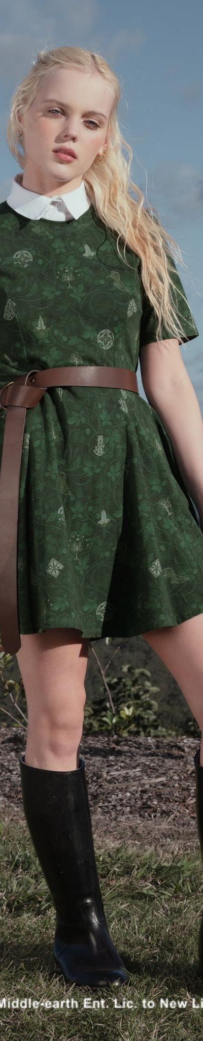 A woman wearing a green printed Black Milk dress with a brown belt and knee-high boots