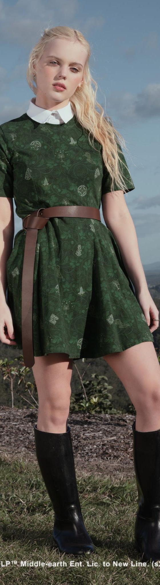 A woman wearing a green printed Black Milk dress with a brown belt and knee-high boots