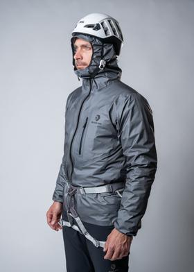 A man in a climbing helmet wearing a grey BLACKYAK Javari Gore-Tex shell jacket