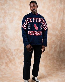 A man wearing a navy BLK FRVR Black Forever University long-sleeve jersey