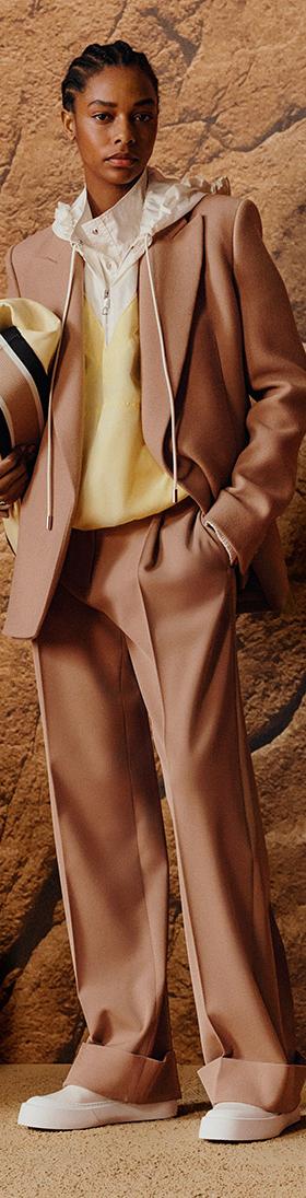 A woman wearing a camel BOSS tailored suit with a pale yellow knit