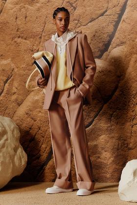 A woman wearing a camel BOSS tailored suit with a pale yellow knit