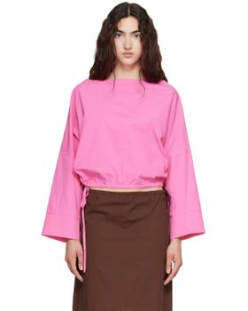 A woman wearing a pink Brooke Callahan cotton poplin top with a brown poplin skirt