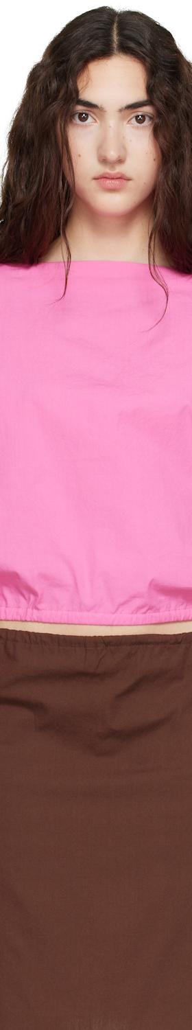 A woman wearing a pink Brooke Callahan cotton poplin top with a brown poplin skirt