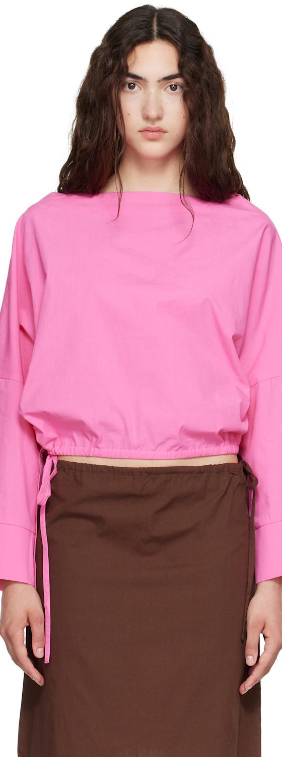 A woman wearing a pink Brooke Callahan cotton poplin top with a brown poplin skirt