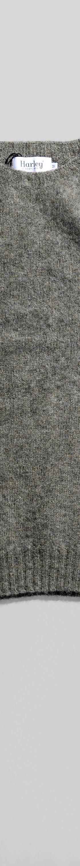 A grey brushed wool crewneck sweater laid flat on a soft white background