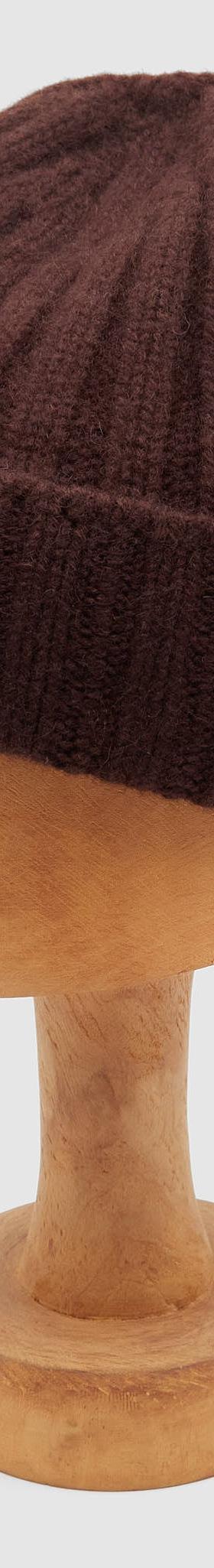 A dark brown ribbed wool Câbleami knit cap displayed on a wooden hat block