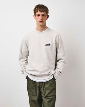 A man wearing an oatmeal Café Mountain sweatshirt with olive ripstop trousers