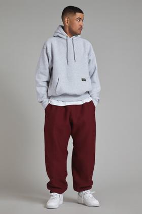 A man wearing a grey Camber USA heavyweight hooded sweatshirt with burgundy sweatpants