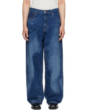 A man wearing blue CAMPERLAB jeans with black leather shoes