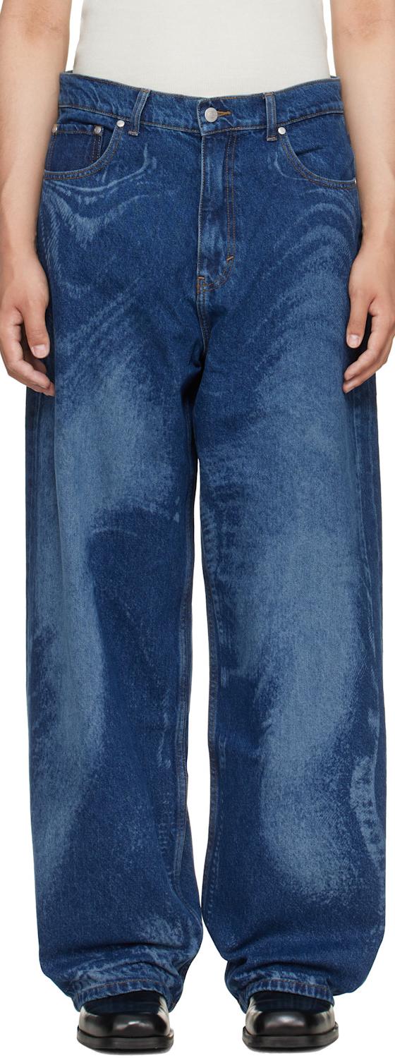 A man wearing blue CAMPERLAB jeans with black leather shoes