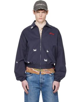 A man wearing a navy Carne Bollente embroidered bomber jacket and cap