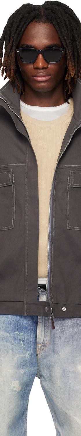 A man wearing a grey CARRER zip blouson with contrast stitching and faded jeans