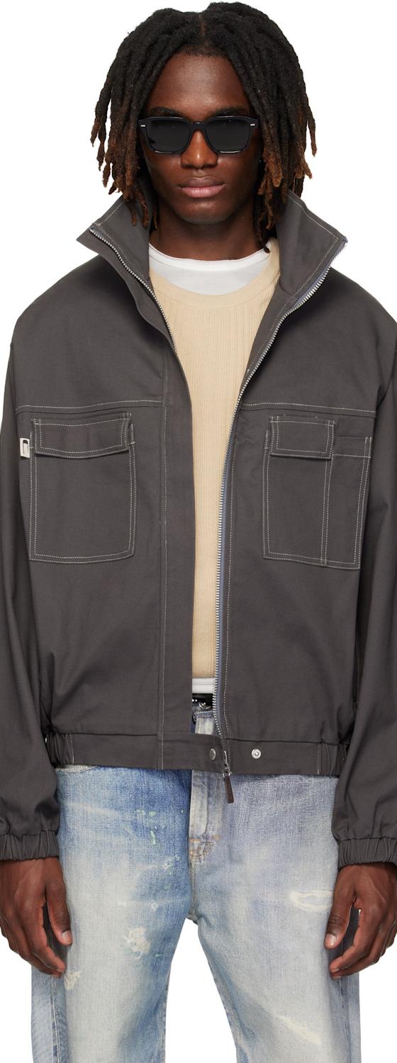 A man wearing a grey CARRER zip blouson with contrast stitching and faded jeans