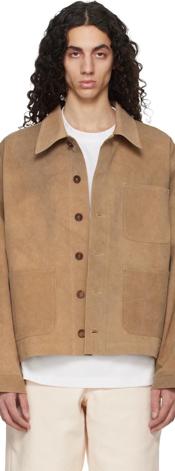 A man wearing a tan suede Colbo jacket over a white tee and cream trousers
