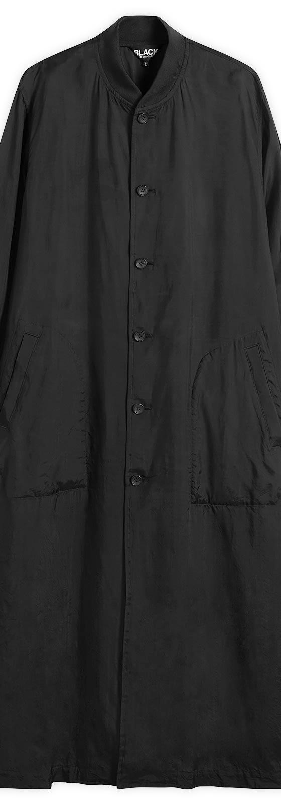 A long black Comme des Garçons Black button-up coat on a plain white background
