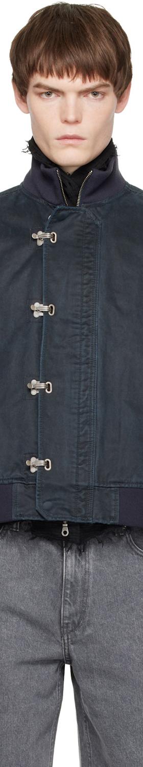 A man wearing a navy COOR blouson jacket with grey jeans