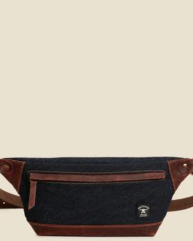 A Craft &amp; Glory denim and leather sling waist bag on a plain cream background