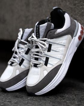 A pair of white and grey Cruyff sneakers with grey suede overlays