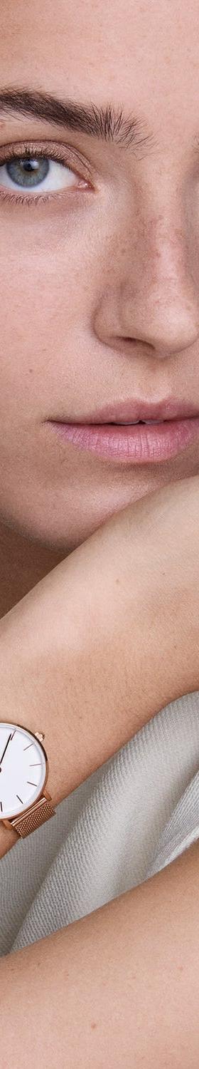 A woman wearing a rose gold Daniel Wellington mesh watch and bangle