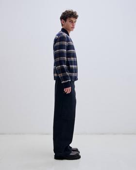 A man wearing a navy check DARKPARK bomber jacket with black Adrian cargo trousers