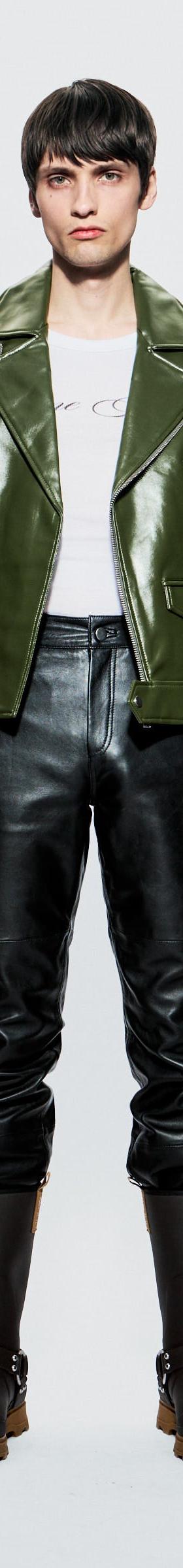 A model wearing a green Deadwood leather biker jacket with black leather trousers and boots