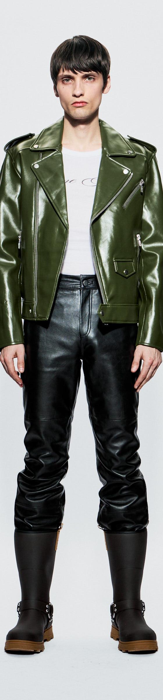 A model wearing a green Deadwood leather biker jacket with black leather trousers and boots