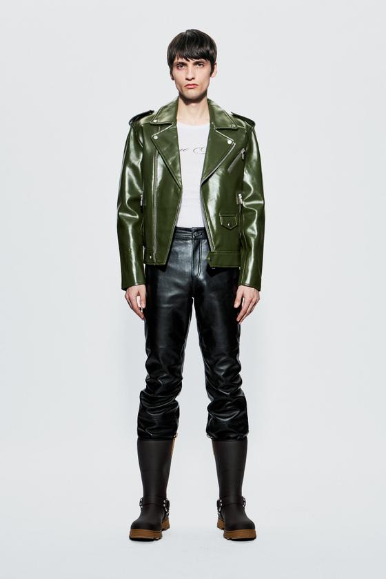 A model wearing a green Deadwood leather biker jacket with black leather trousers and boots