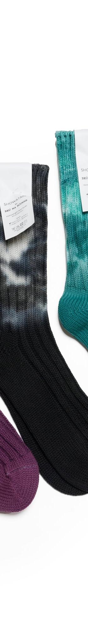 Five pairs of decka Quality Socks in tie-dyed red, purple, black, teal and yellow ribbed cotton on a white background