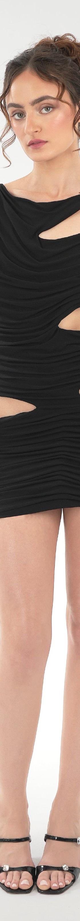 A woman wearing a black draped Di Petsa mini dress with cut-outs