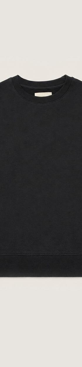 A black organic cotton crewneck sweatshirt on a plain cream background