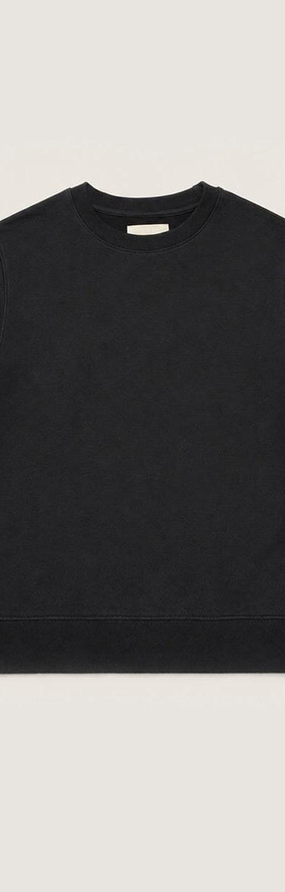 A black organic cotton crewneck sweatshirt on a plain cream background