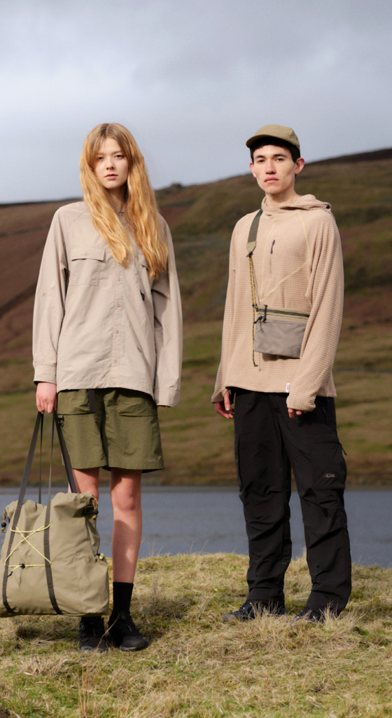Two models in the hills, one carrying an olive Elliker tote bag and the other a beige crossbody pouch