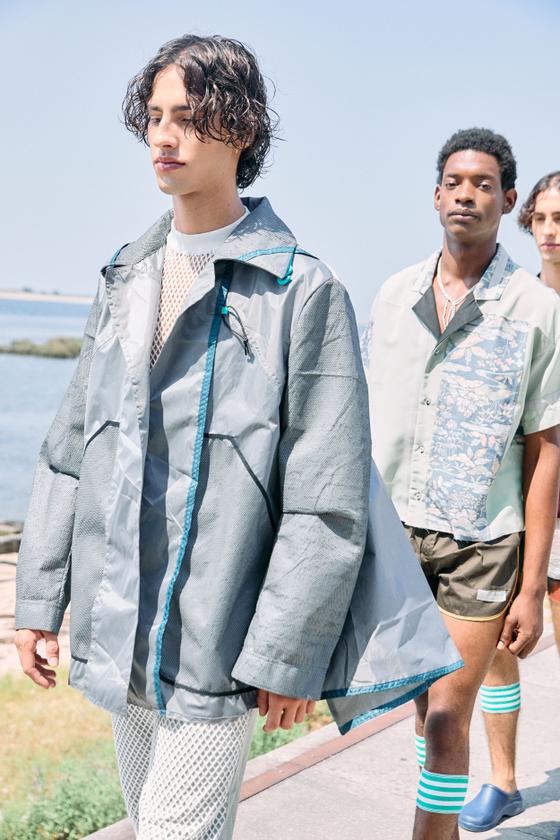 A man wearing a grey Estelita Mendonça deconstructed jacket with teal trim