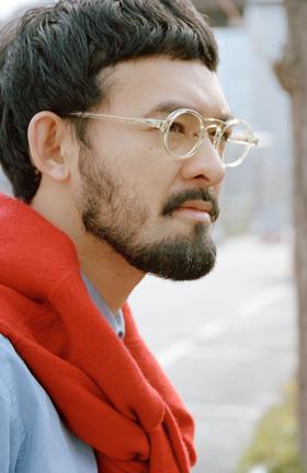 A bearded man wearing clear round EYEVAN 7285 optical frames