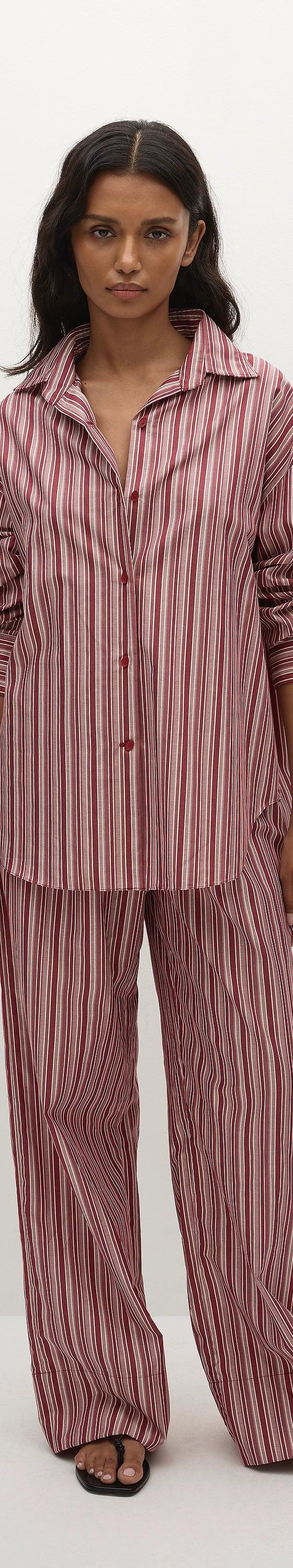 A woman wearing a pink striped Faithfull the Brand shirt and matching wide-leg trousers