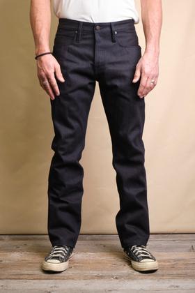 A man wearing raw indigo Freenote Cloth selvedge denim jeans with a white tee and sneakers