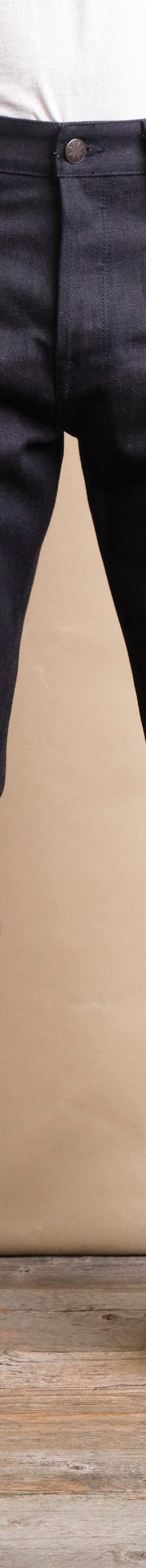 A man wearing raw indigo Freenote Cloth selvedge denim jeans with a white tee and sneakers