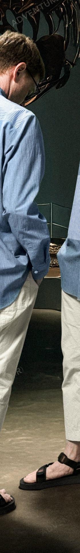 Two men wearing Fumito Ganryu blue striped panelled shirts with cropped cream trousers and sport sandals