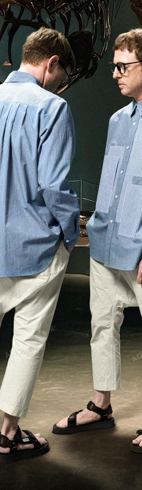 Two men wearing Fumito Ganryu blue striped panelled shirts with cropped cream trousers and sport sandals